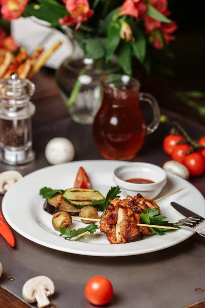 バーベキュー漬けの七面鳥や鶏肉料理ケバブ串ケチャップソースと素朴な木製のテーブルの背景に焼き野菜と串焼き 伝統的なバーベキューグリル料理 — ストック写真