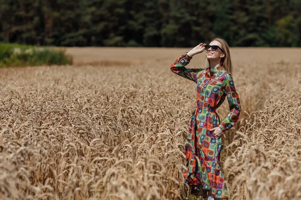 Une belle jeune femme marche dans un champ de blé — Photo