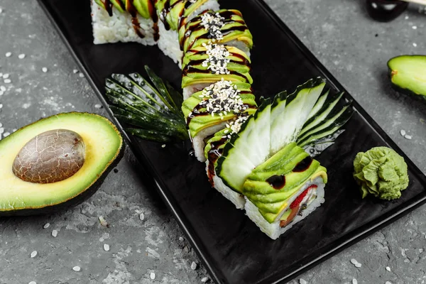 Zöld sárkány sushi tekercs angolna, avokádó, uborka és gyömbér, kíséretében sült tempura garnélarák. Hagyományos ázsiai rizs sushi egészséges tengeri ételek — Stock Fotó