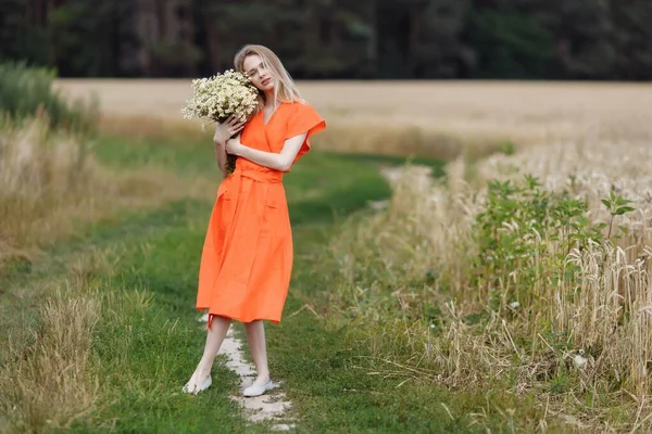 Красивая молодая женщина идет по пшеничному полю — стоковое фото