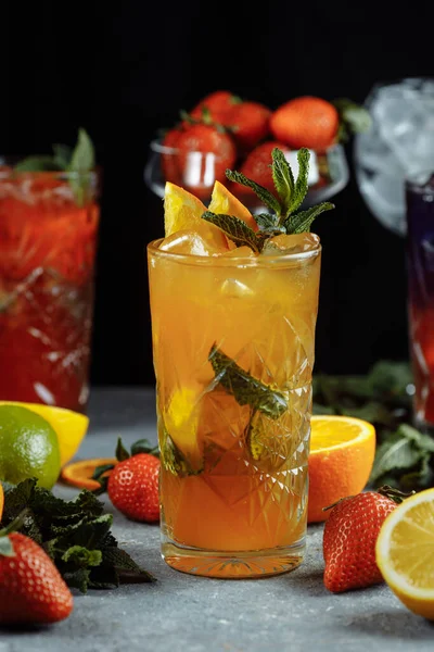 Bebidas refrescantes coloridas para o verão, suco de limonada de morango frio com cubos de gelo nos óculos decorados com limões frescos fatiados — Fotografia de Stock