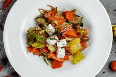 Taze sebzeli Yunan salatası, peynir ve siyah zeytin.