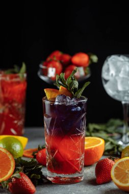 Yaz için renkli ferahlatıcı içecekler, dilimlenmiş taze limonlarla süslenmiş buzlu soğuk çilekli limonata suyu.