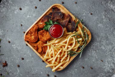 Atıştırmalıklı tabak. kızarmış tavuk nugget, kızarmış patates ve jamon.