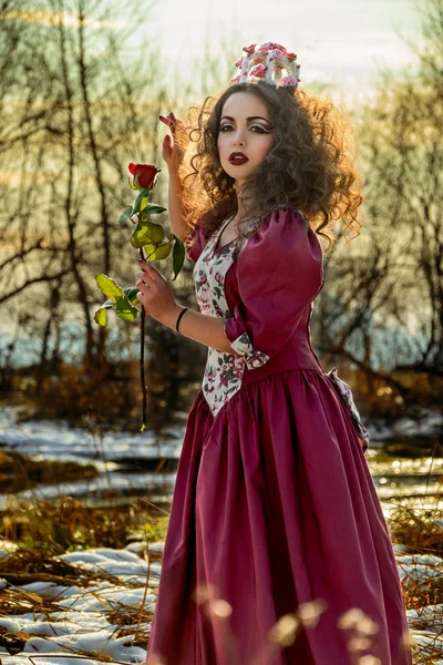 Piękna dziewczyna w vintage czerwona sukienka z różą — Zdjęcie stockowe