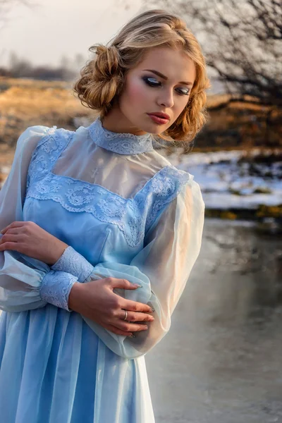 Portret van romantische vrouw in een jurk op de oever van de rivier — Stockfoto