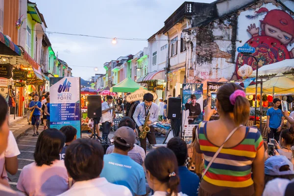 PHUKET, TAILANDIA 29 DE MAYO DE 2016: Músico toca saxofón jazz en el mercado nocturno de Phuket el 29 de mayo de 2016.Entre el antiguo edificio de estilo Chino portugués, la calle de la ciudad de Phuket es el famoso popular — Foto de Stock