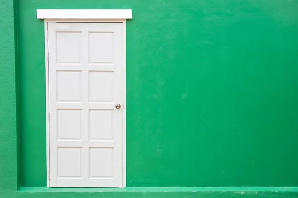 Белая дверь классический винтаж на зеленом фоне стены цвета — стоковое фото