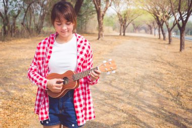 Açık havada ukulele gitar çalan güzel Asyalı kadınlar