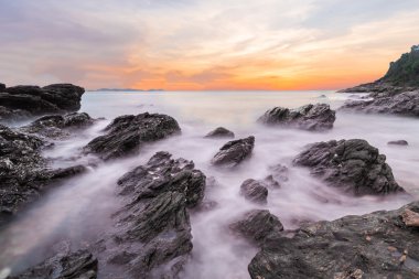 Khao Laem Ya Mu Ko Samet Milli Parkı Rayong, Tayland plajön planda taşlarla gün batımında okyanus yumuşak dalgalar. Seascape uzun pozlama çekim