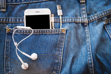Beyaz smartphone cep Mavi Jeans kulaklık ve veri aktarımı veya bilgi için Usb kablosu ile