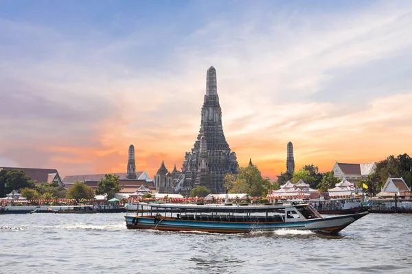 De tempel van de dageraad, Wat Arun, op de Chao Phraya-rivier met passagiersschepen of boot en een mooie hemel in twilight tijd in Bangkok, Thailand — Stockfoto