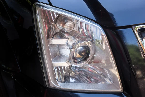 Närbild strålkastarna av modern svart bil med projektorns lins — Stockfoto