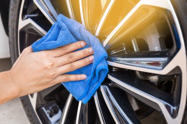 El araba tekerlek Temizleme mavi mikrofiber bezle.