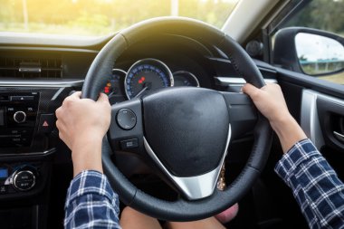 Close-up Of Woman's Hand Holding Steering Wheel for car driver clipart