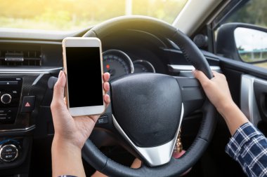 Dokunmatik ekran smartphone ve arabada direksiyon tutan el kullanarak genç kadın sürücü.