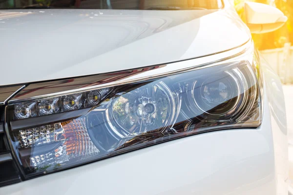 Closeup headlights of modern white car with LED daylight running