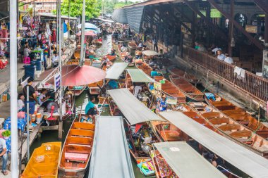 Ratchaburi-Tayland 27 Temmuz 2017: Damnoen Saduak Suüstü Pazarı Tayland 'ın ünlü nehri üzerinde geleneksel ahşap tekneler kullanan bir ticaret ve gıda pazarıdır..