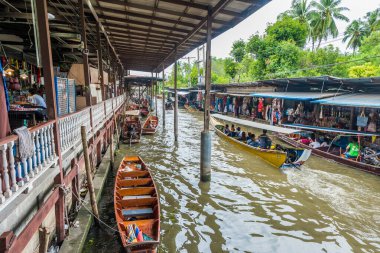 Ratchaburi-Tayland 27 Temmuz 2017: Damnoen Saduak Suüstü Pazarı Tayland 'ın ünlü nehri üzerinde geleneksel ahşap tekneler kullanan bir ticaret ve gıda pazarıdır..