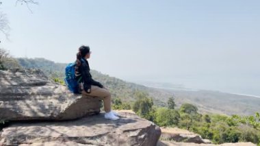 Kadın turistler oturur ve geniş manzaralara hayran kalır ve temiz havayı içine çekerler..