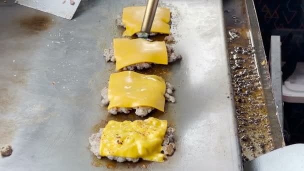 厨师把奶酪放在肉上 然后把火烧掉 让奶酪融化在锅里 — 图库视频影像