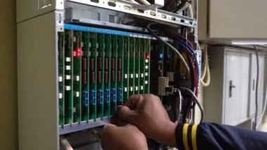 Teknisyen veya mühendis anakart, PBX, dijital sistem bağlantısını gösteren yanıp sönen ışıklarla telefon değiştirir
