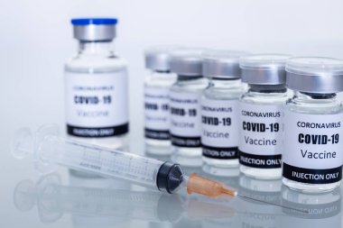 Koronavirüsü veya kovid 19 'u önlemek için bir sürü aşı şişesi ve şırınga. Odaklanmayı seç