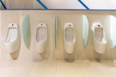 Modern bir süpermarkette otomatik doldurma sensörleri ve durduruculu beyaz pisuar..
