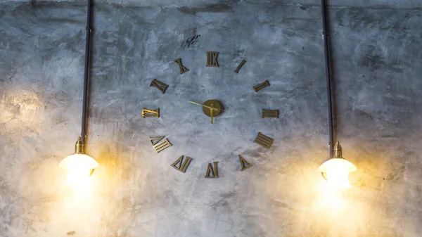 Cement wall with vintage clock and light bulbs — Stock Photo, Image