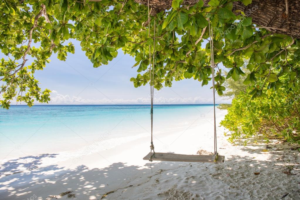 Swing on beautiful crystal clear sea and white sand beach