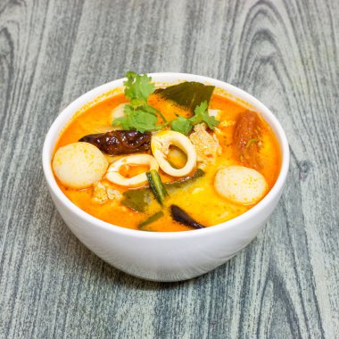 Ahşap arka plan üzerinde Tom Yum Kung-Tay baharatlı çorba