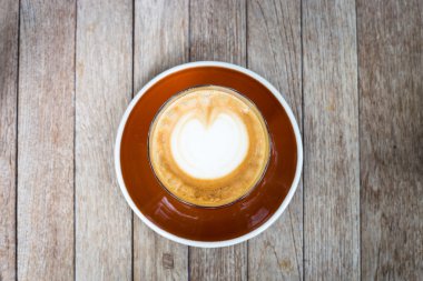 Latte sanat tahta arka plan ile kahve çizim kalp