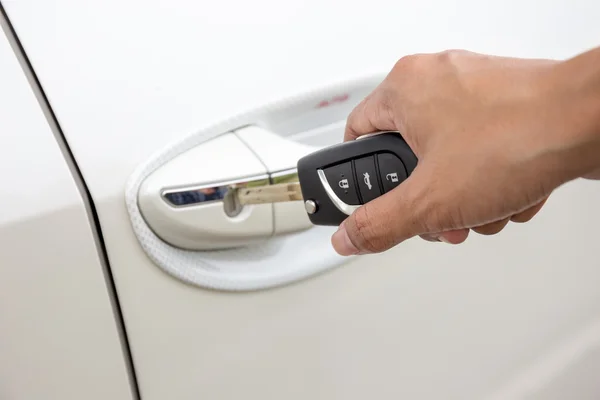 Bir anahtar beyaz bir araba kapı kilit eklemeden bir kadın eli closeup. (odak butonunun anahtar) — Stok fotoğraf