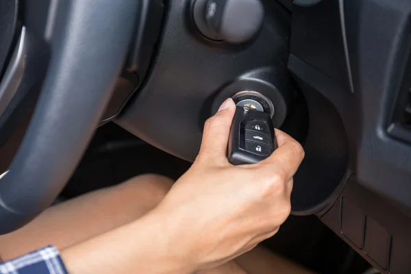 Women driver hand inserting car key and starting engine. — Stock Photo, Image