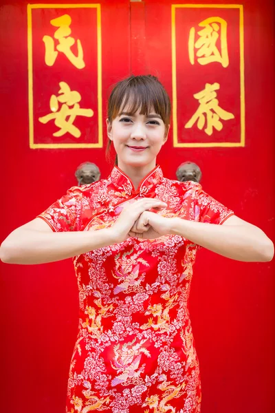 Καλή Κινέζικη Πρωτοχρονιά. Χαριτωμένη Ασιάτισσα γυναίκα με χειρονομία συγχαρητηρίων απομονώνονται σε κόκκινο κινέζικο μοτίβο παραδοσιακό υπόβαθρο (κείμενο "τυχερός" "safeguard") — Φωτογραφία Αρχείου