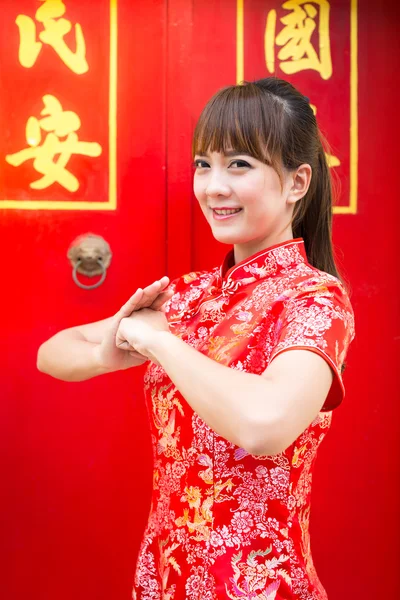 Frohes chinesisches neues Jahr. Nette asiatische Frau mit Geste der Gratulation isoliert auf rotem chinesischem Muster traditionellen Hintergrund (Text "Glück" 'Schutzschild') — Stockfoto