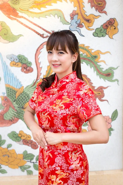 Ευτυχισμένος Κινέζοs νέο έτος. Χαριτωμένο γυναίκα της Ασίας με τη χειρονομία της συγχαρητήρια που απομονώνονται σε κόκκινο κινεζική παραδοσιακή φόντο του χαρτιού καλύπτεται — Φωτογραφία Αρχείου