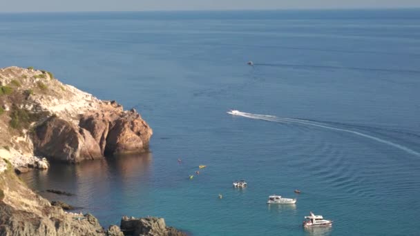 Una moto d'acqua attraversa rapidamente il mare oltre una scogliera in una giornata estiva. Il concetto di svago e turismo. Filmati 4k di alta qualità — Video Stock