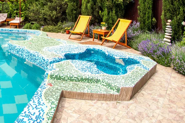 Sun loungers on decks at waterfront of a side of swimming pool. For relaxation and recreation in front of room at hotel resort. — Stock Photo, Image