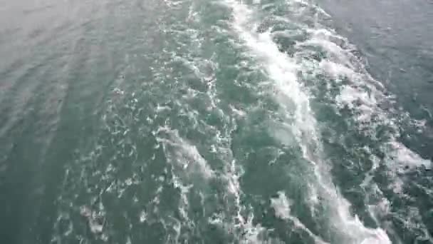 Ondas poderosas emanando de um barco em movimento rápido, um enorme fluxo de água verde com espuma branca em ascensão, um tiro bonito e estável ideal para cinema, composição digital, mapeamento de vídeo — Vídeo de Stock