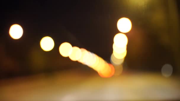 Nieostre piękne błyszczące rozmyte bokeh samochodów i świateł w nocy. Niewyraźne korki na ulicy miejskiej. rozproszone kolorowe światła korków na ulicy miejskiej — Wideo stockowe