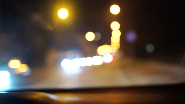 Nieostre piękne błyszczące rozmyte bokeh samochodów i świateł w nocy. Niewyraźne korki na ulicy miejskiej. rozproszone kolorowe światła korków na ulicy miejskiej — Wideo stockowe