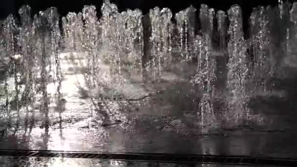 Wasserstrahlen vom Stadtbrunnen im Park im Sonnenuntergang. Kinder rennen in den Brunnen. Wasserdruck und -druck. Spritzwasser. Zeitlupe. Nahaufnahme — Stockvideo