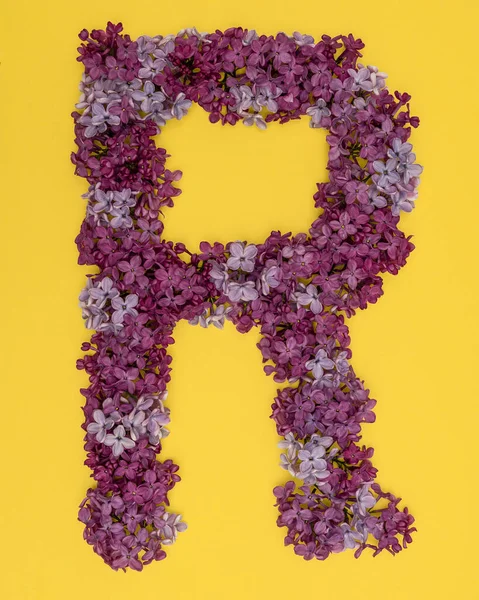 The letter R is lined with lilac flowers on a yellow background. For lettering, composing words.