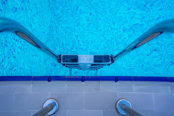 Latar belakang air transparan biru di kolam renang di wilayah hotel. Turun ke kolam dengan handrails. Istirahat dan rileks konsep. Aktif sisanya oleh laut — Stok Foto
