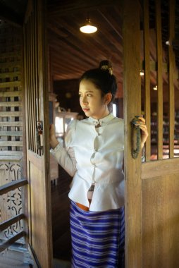 Tayland 'ın Chiang Mai şehrinde eski bir evde geleneksel Tayland Lanna elbisesi içinde güzel bir Asyalı kadın..