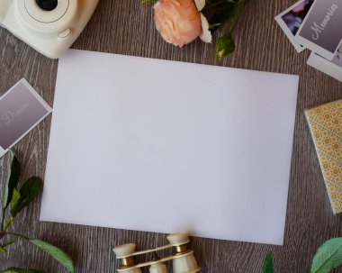 Tasarım elementleri, tahta arka planda boş bir kağıt. Üst Manzara, konumu kopyala. Kamera, çiçekler, boş fotoğraf kartları, dürbün, metin alanı görüntüsü. Kolaj yapma kavramı