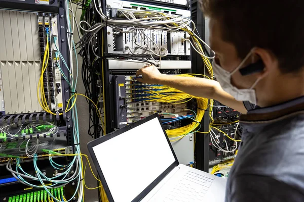 Teknik mühendis kablo odasındaki sunucu ve verilerle ilgili sorunu düzeltiyor