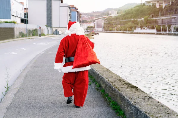 2020 Noel 'inde çocuklara vermek üzere bir çuval dolusu hediyeyle sokakta yürüyen Noel Baba' nın arka portresi