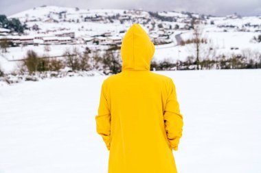 Güzel bir manzarası olan, sarı ceketli ve çok renkli bir görüntü çizen dağdaki bir kadının arka plan görüntüsü.